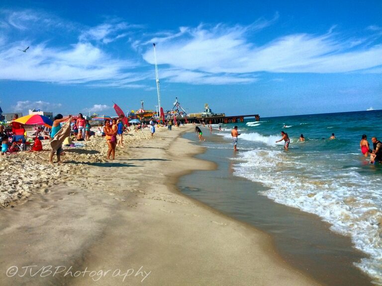 Families playing in the waves on a sunny, busy beach