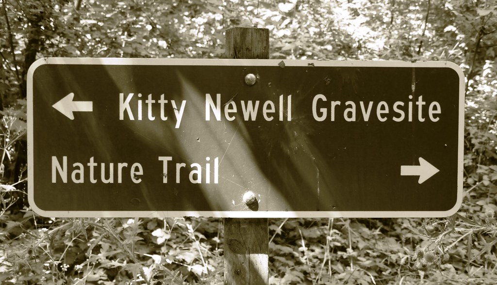 A wooden trail sign at a state park pointing toward a nature trail