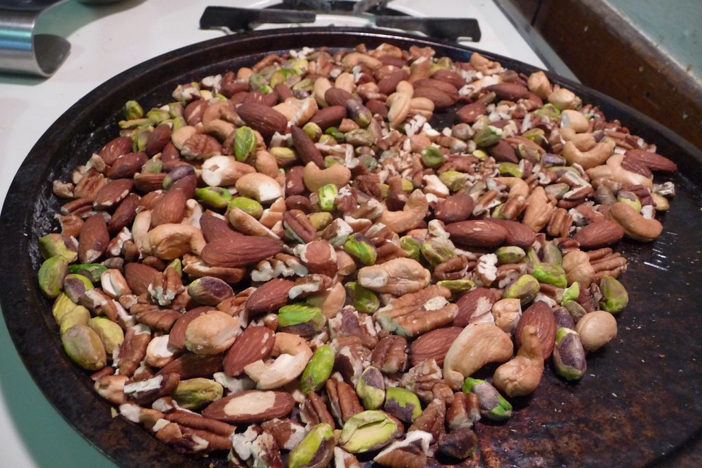 A close-up of roasted mixed nuts and trail mix in a pan